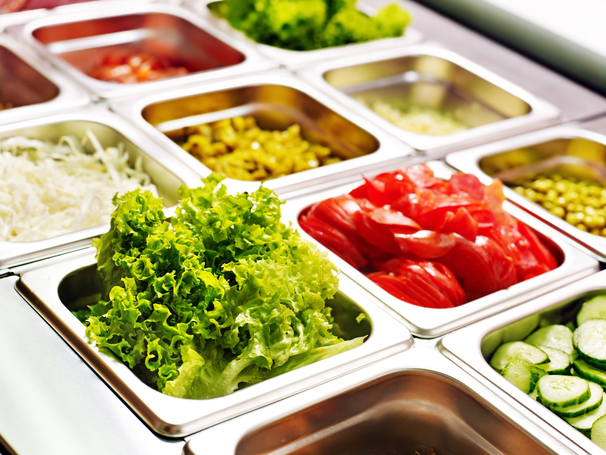 Buffet de ensaladas frescas y coloridas, verduras variadas.